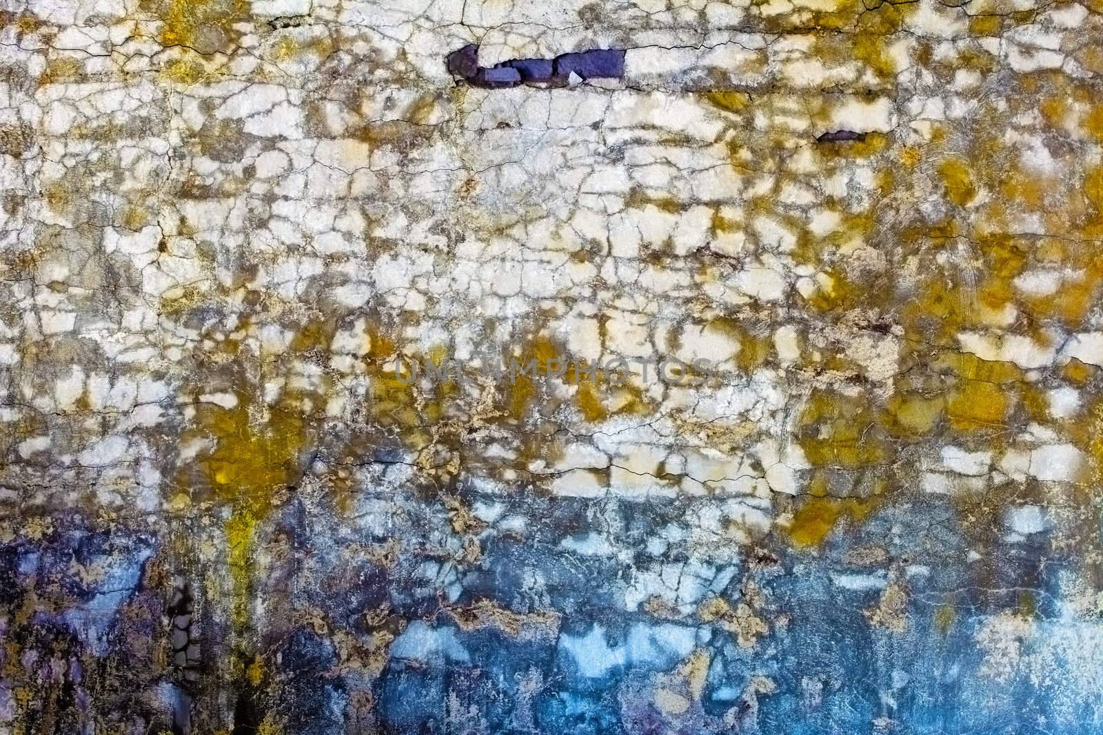 The old concrete wall with colored spots and cracks