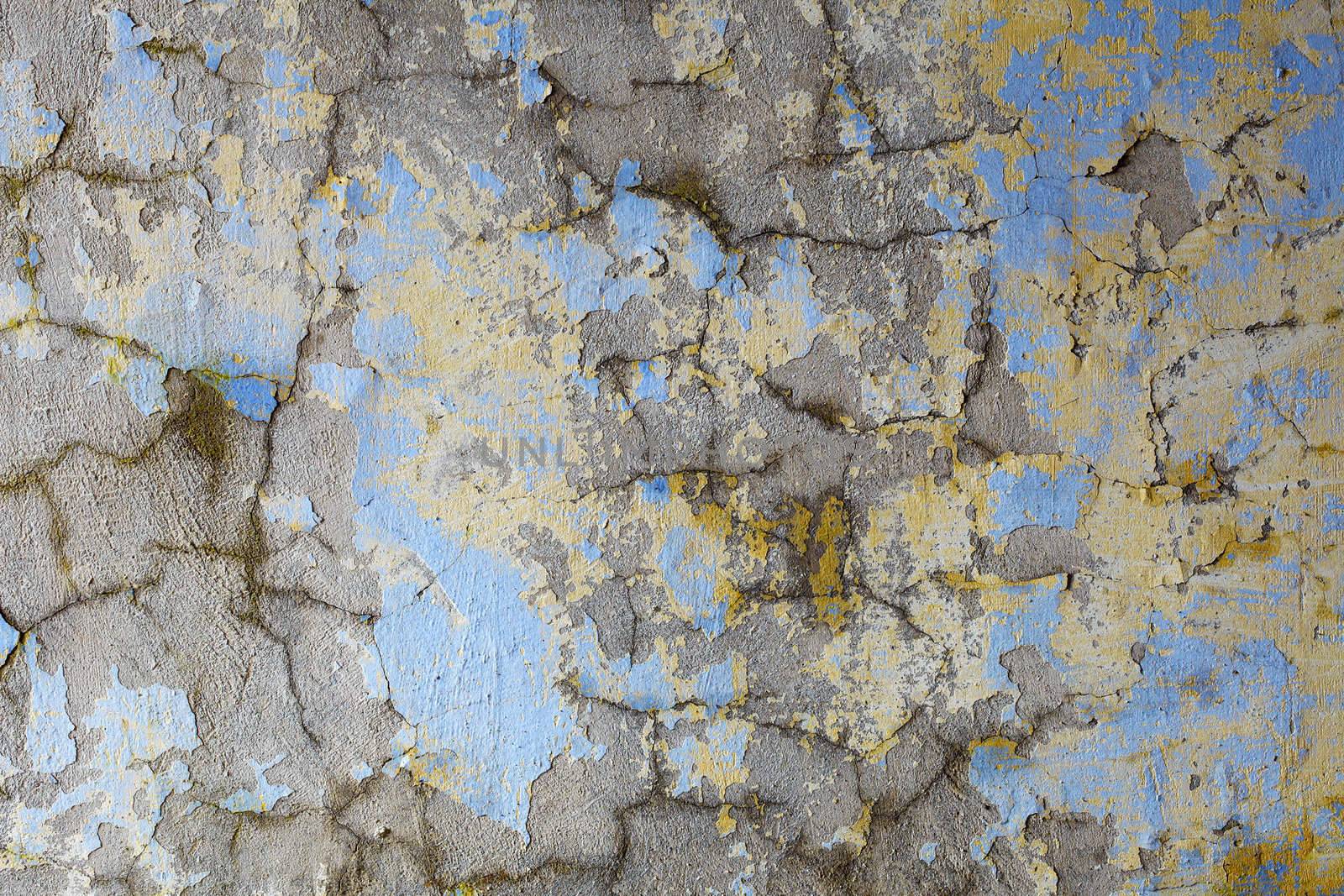 Dirty old wall covered with cracks and paint flakes