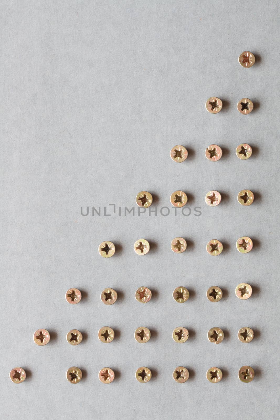 Gray background made from lot of brass screws