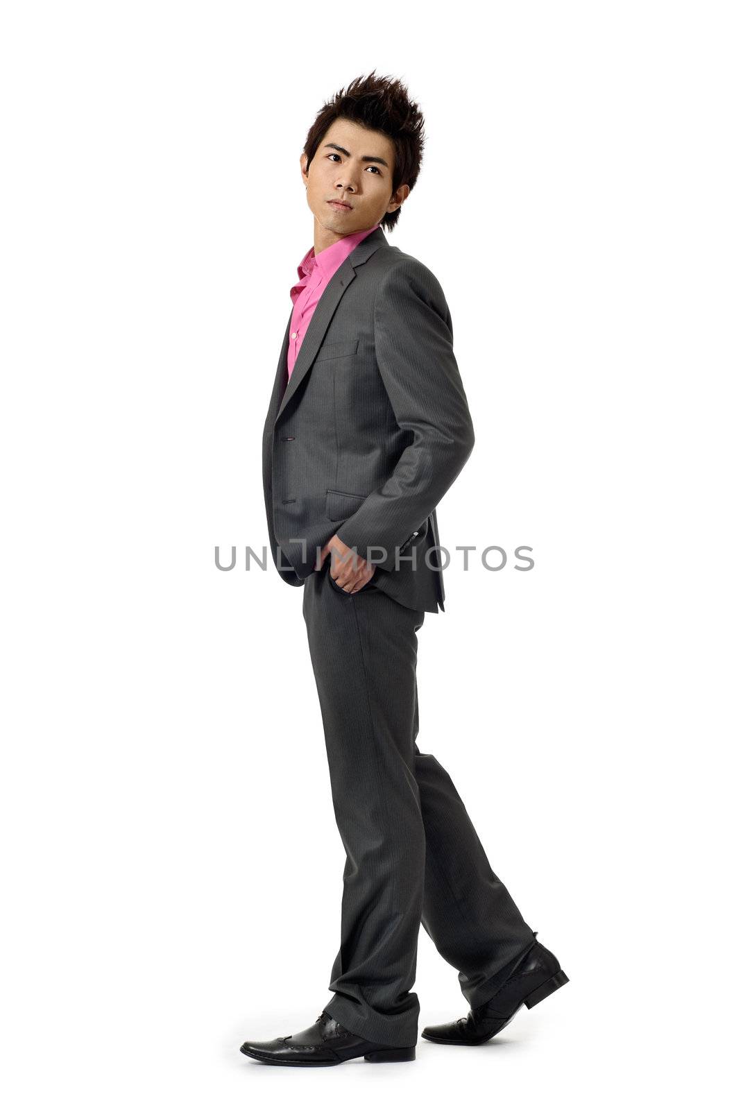 Young businessman walking and watching, full length portrait isolated on white background.