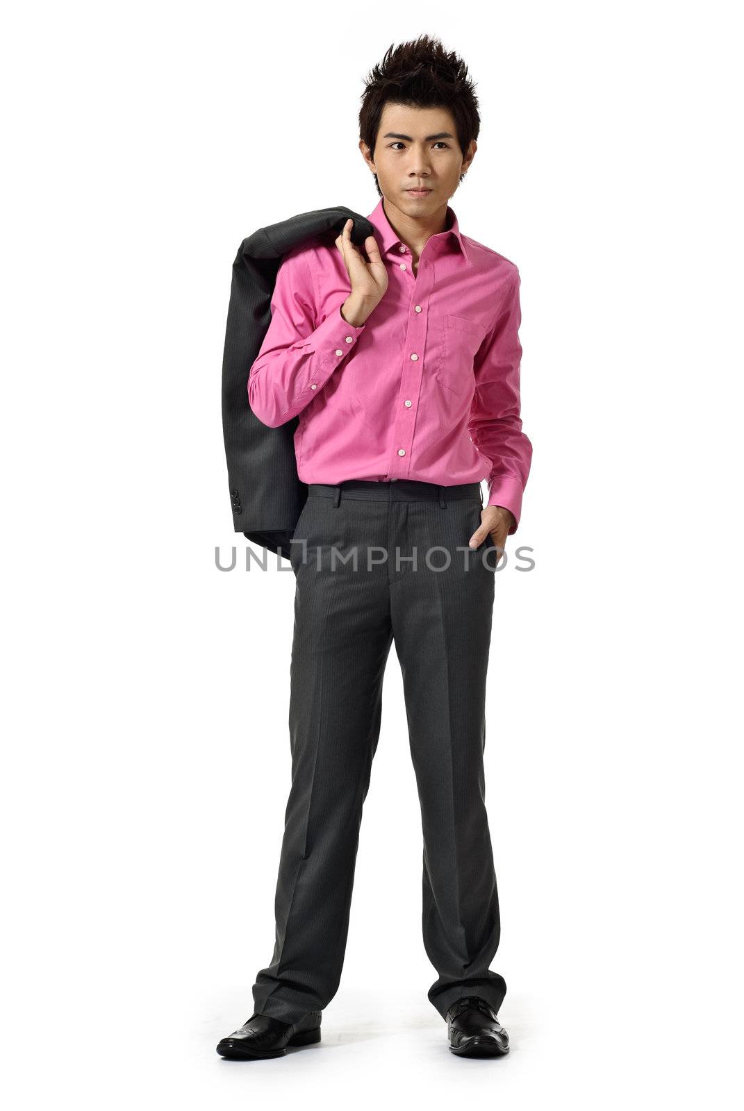 Young businessman with coat on shoulder standing against white background.