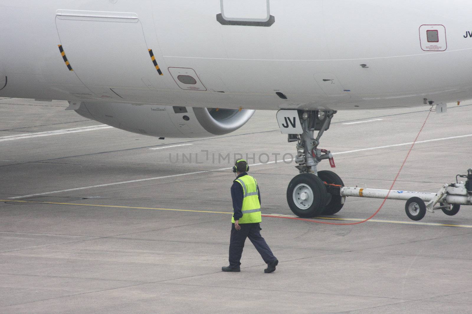 Aircraft departure controller connected to the cockpit and guiding the aircraft out during initial pushback.