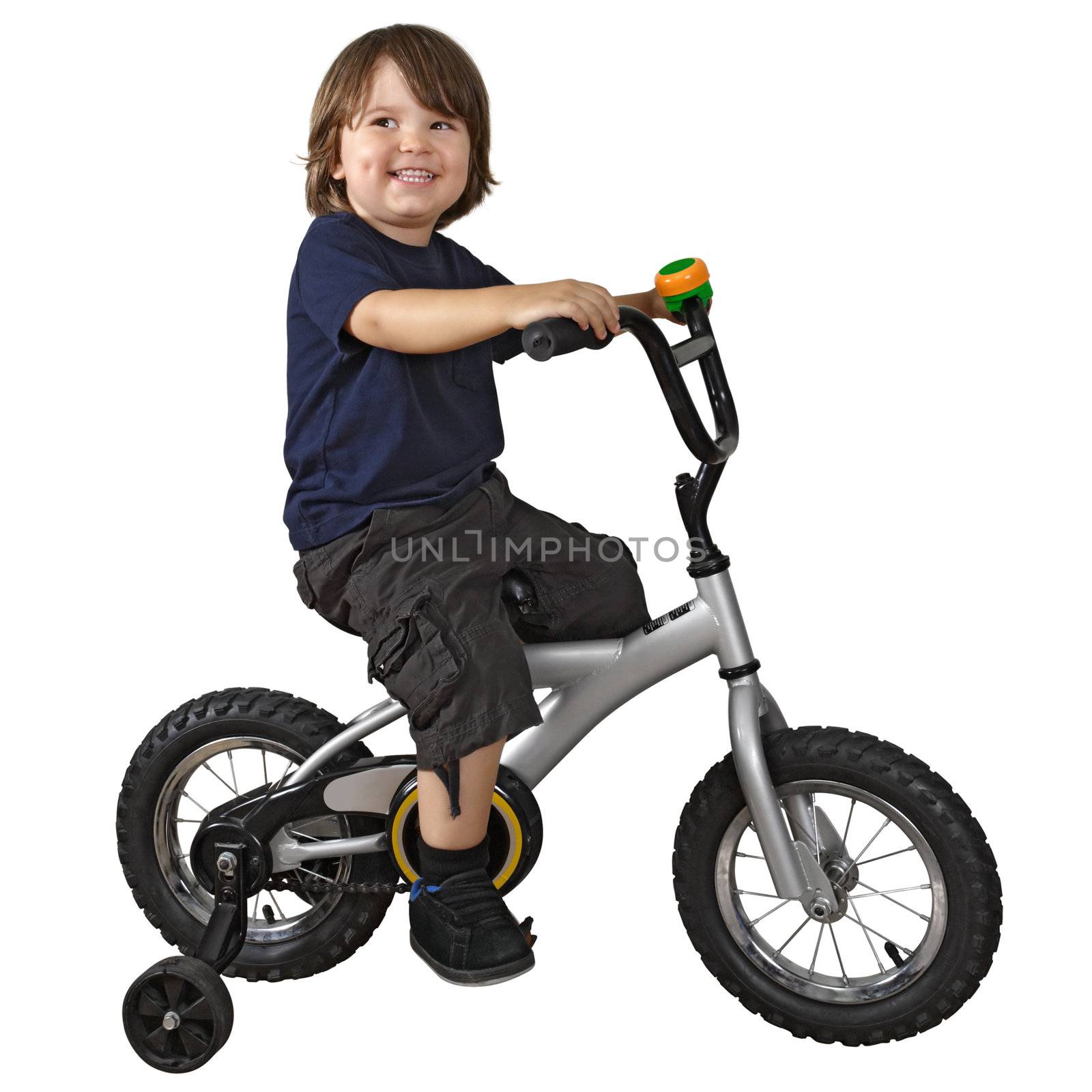 An adorable 3-year-old riding his bicycle fitted with training wheels.