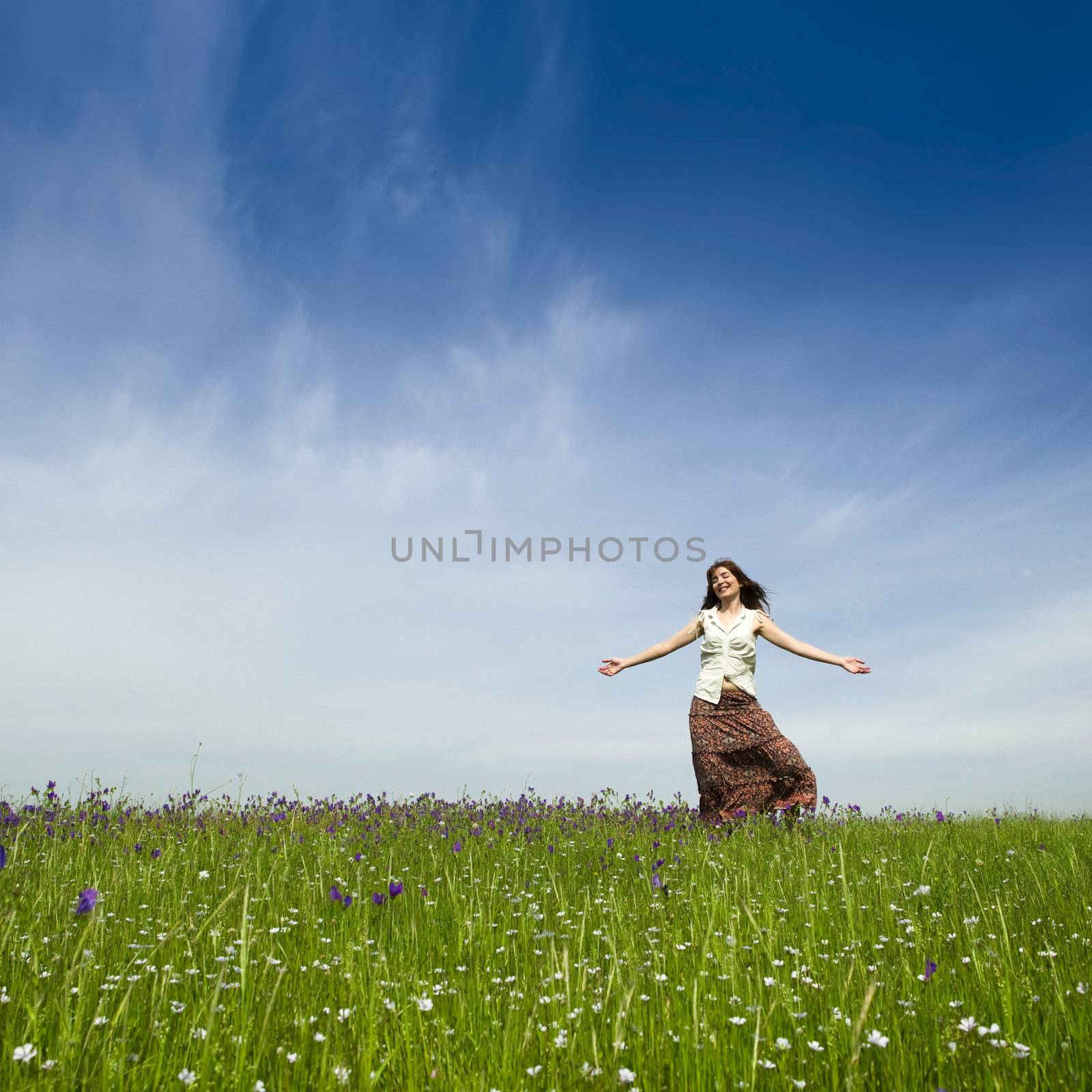 Young woman dancing on a beautiful green meadow