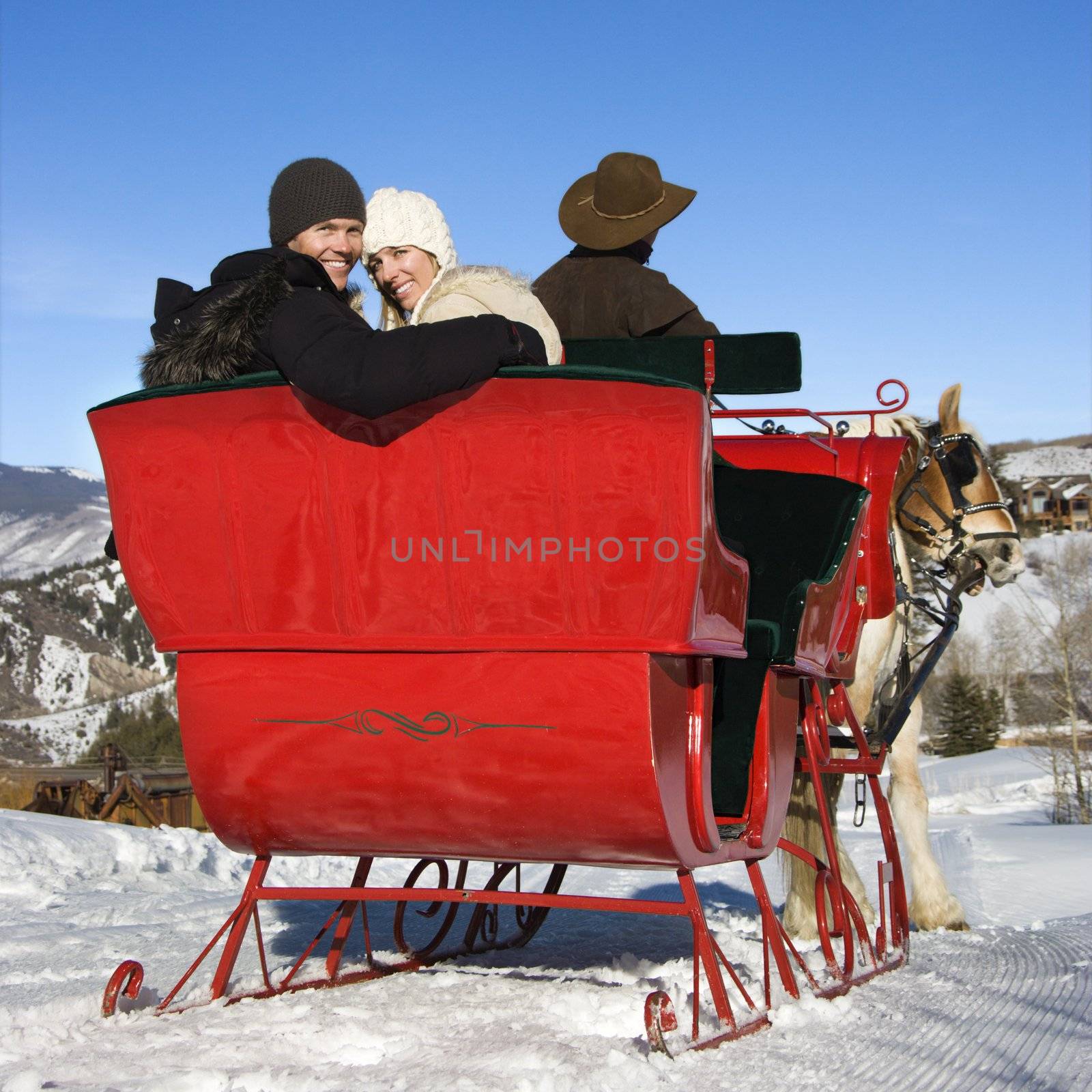 Young couple on sleigh ride. by iofoto