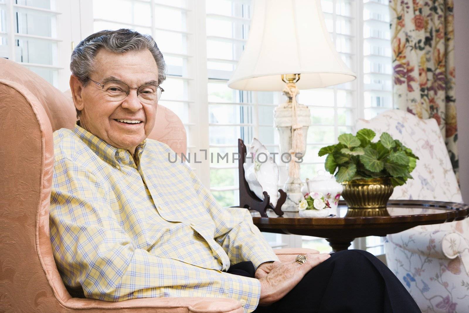 Portrait of mature Caucasian man sitting in chair.