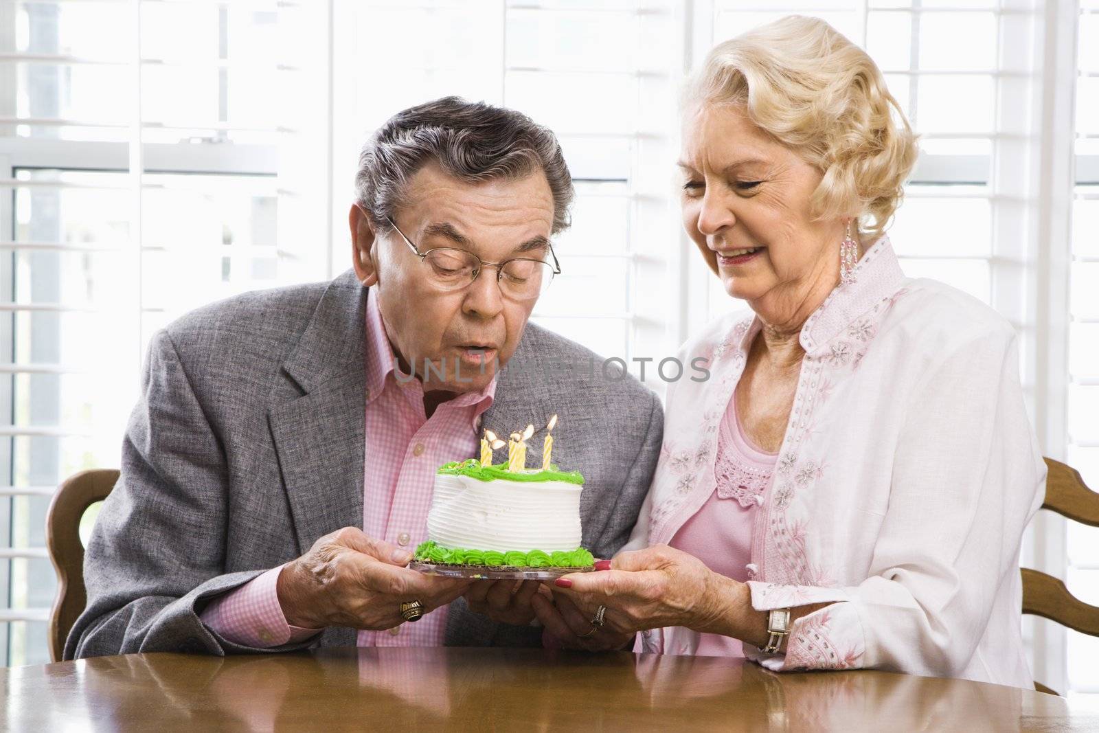 Mature couple with cake. by iofoto