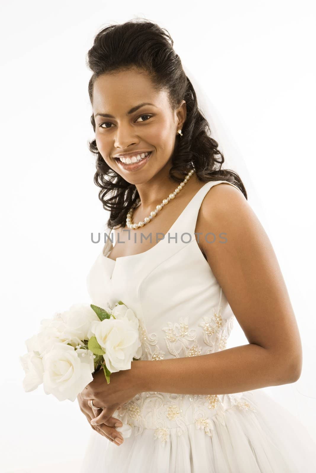 Portrait of a mid-adult African-American bride holding bouquet.