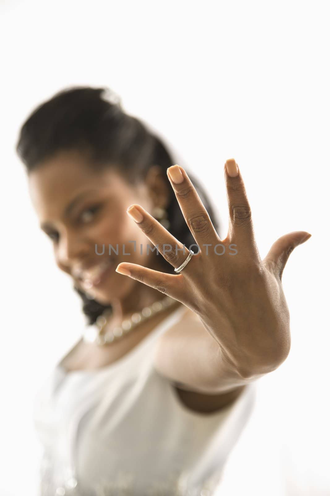 Portrait of a mid-adult African-American bride showing ring to viewer.