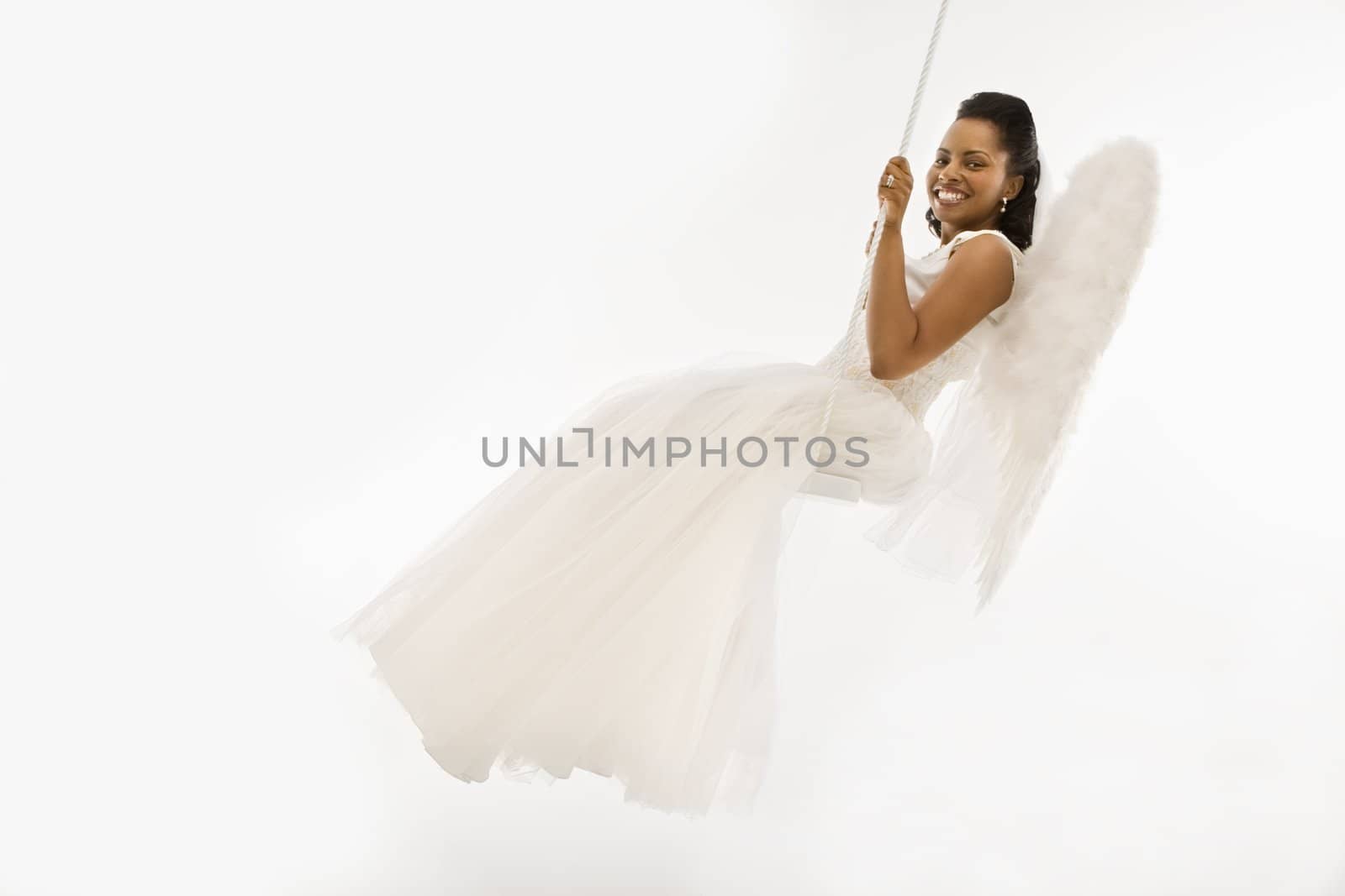 Angelic Mid-adult African-American bride swinging.