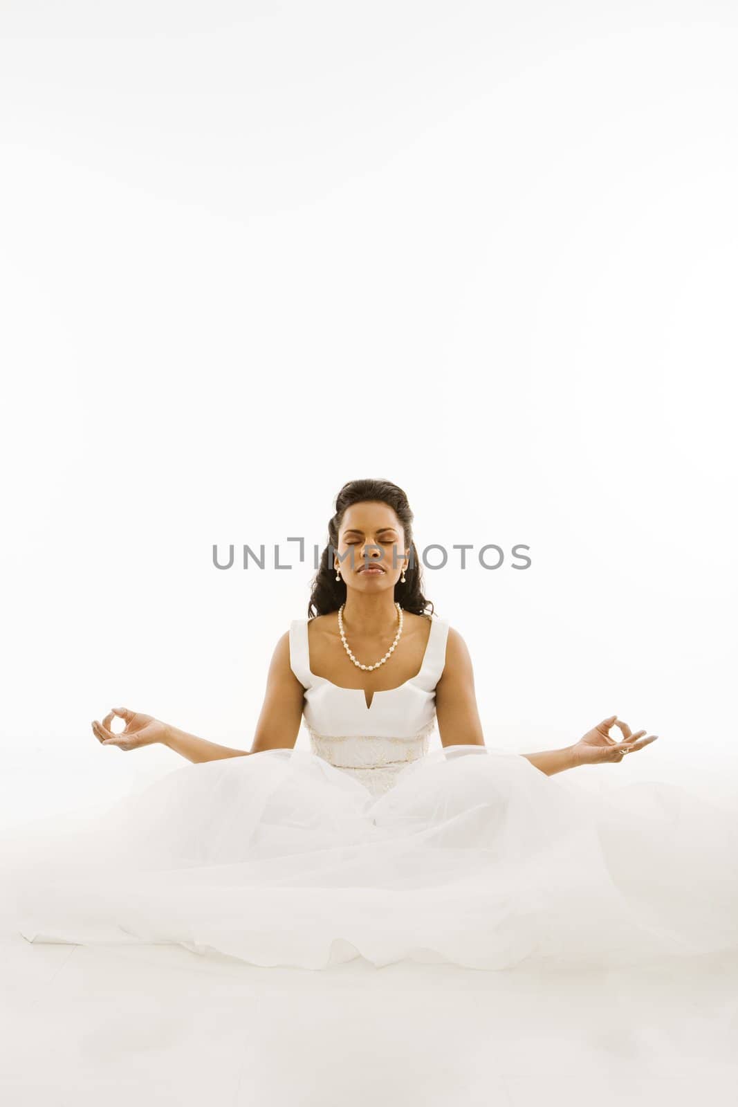 Mid-adult African-American bride mediating with white background.