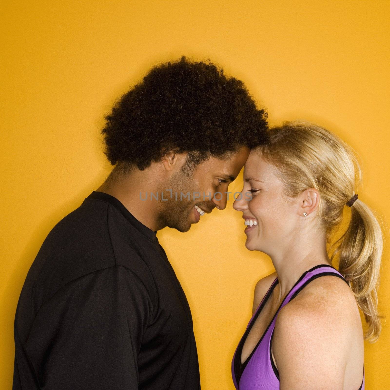 Caucasian woman with head against African-American male's head.
