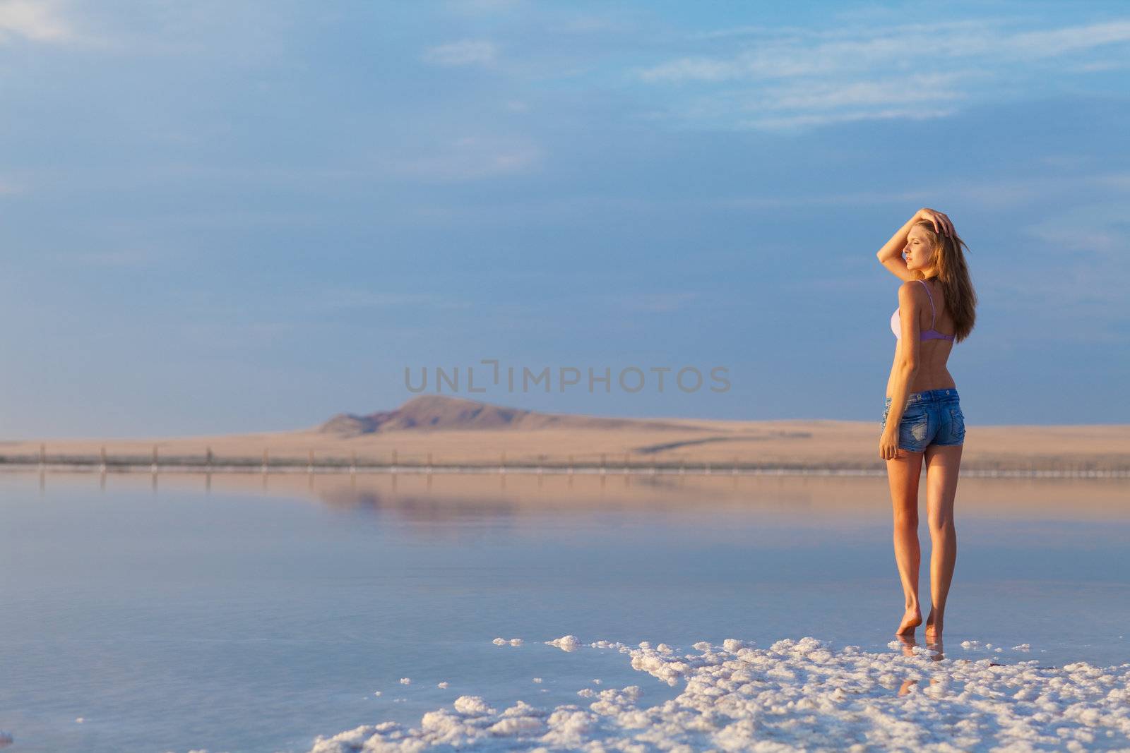 girl in a salt lake in a sunrise
