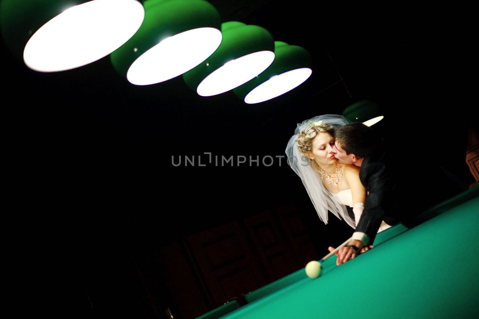 bride playing billiard at night