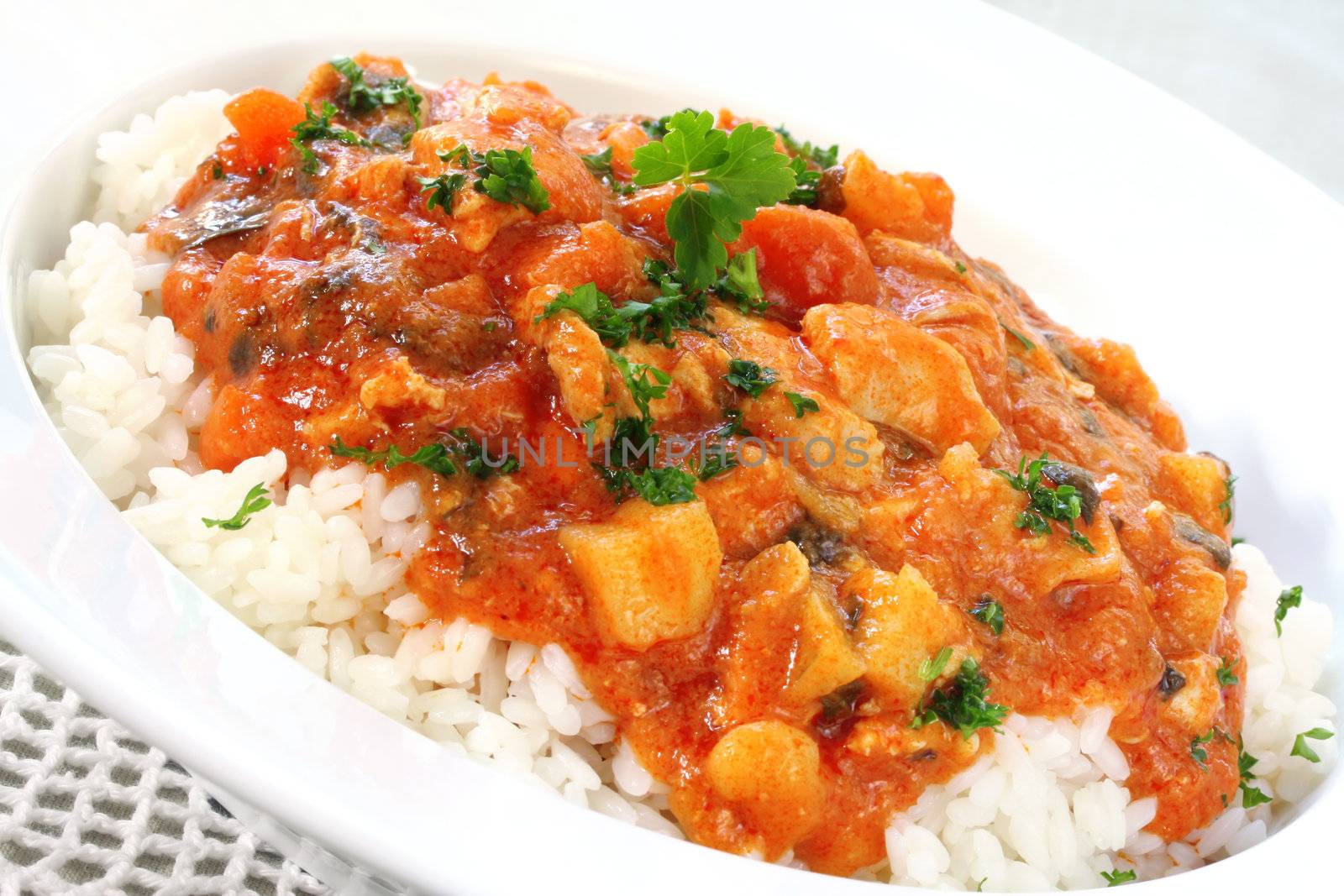 A bowl of chicken curry over steamed white rice.