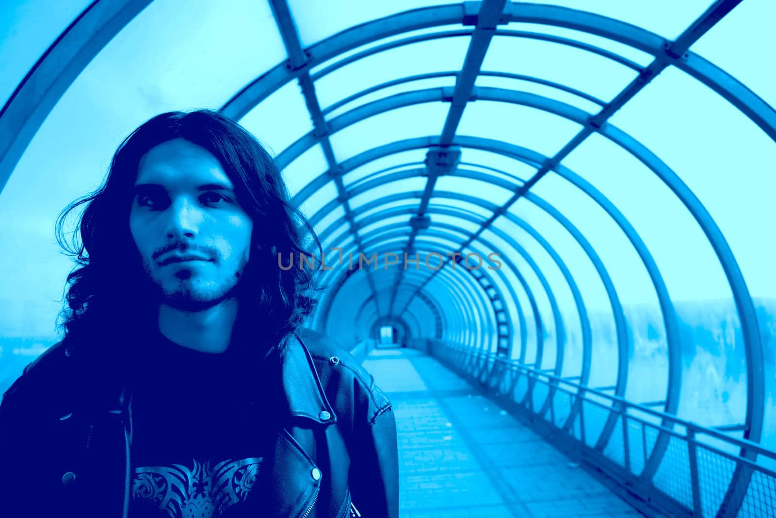 closeup portrait long-haired men in transparent turn blue glass tunnel