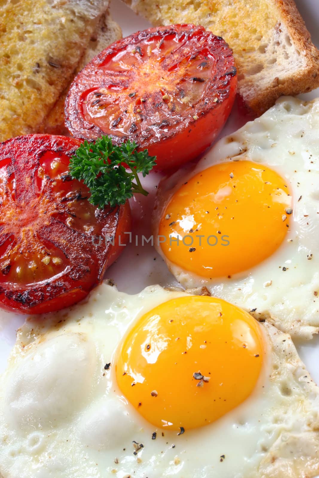 Breakfast of fried eggs, tomatoes and wholewheat toast.