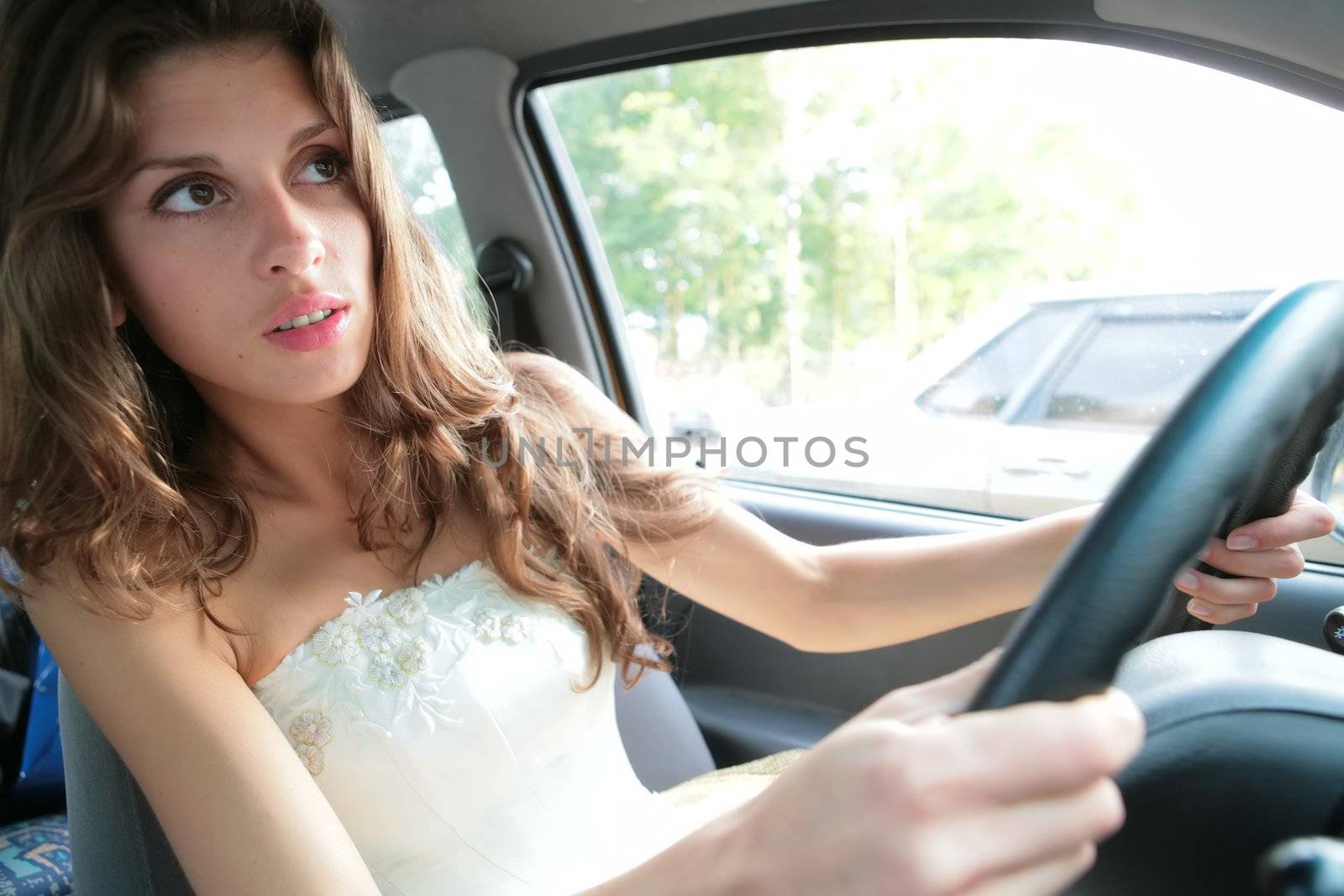 luxurious brunette in white cloth emotional controls car