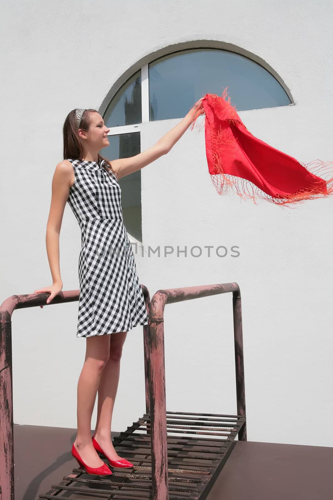beautiful girl in plaid dress with red kerchief on winds
