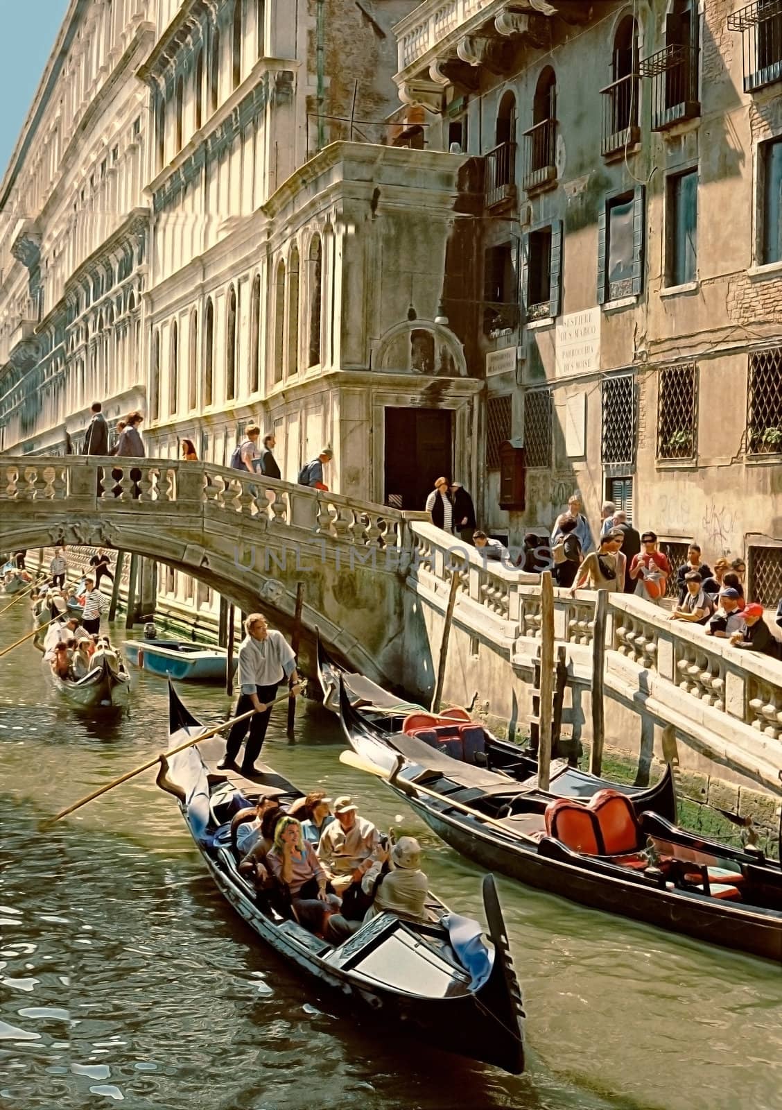 Tourists on foot or in gondolas exploring the delights of Venice.