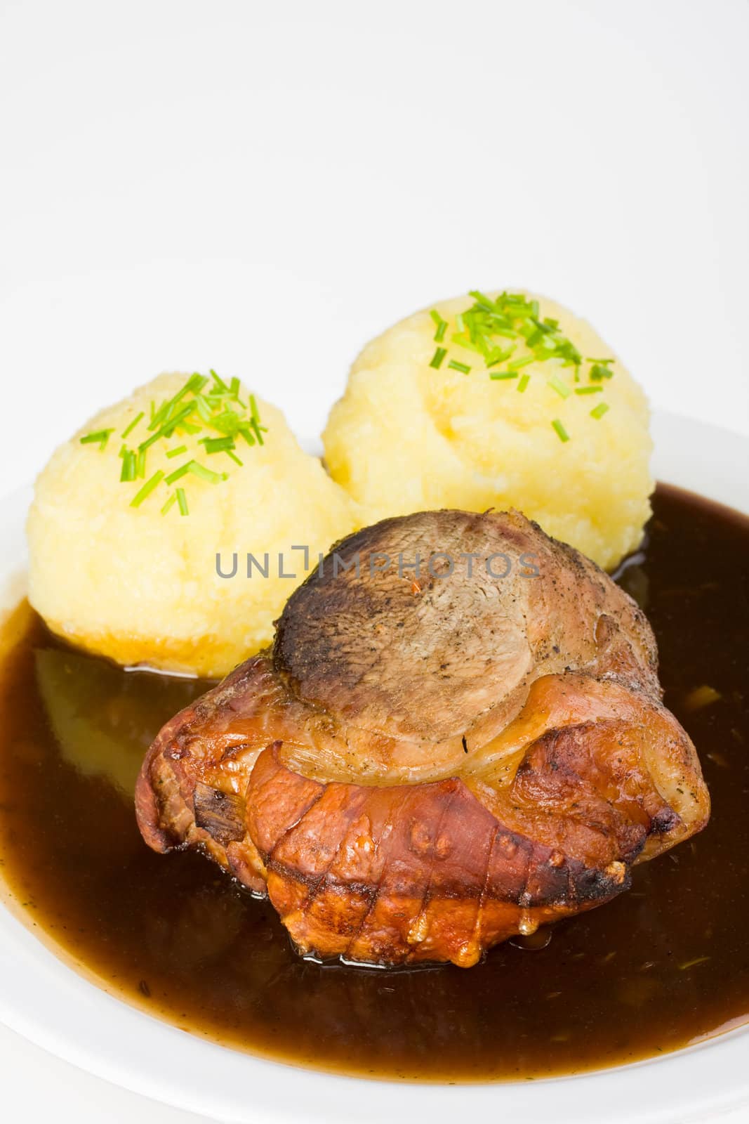 traditional bavarian roast pork with beer sauce and dumplings by bernjuer