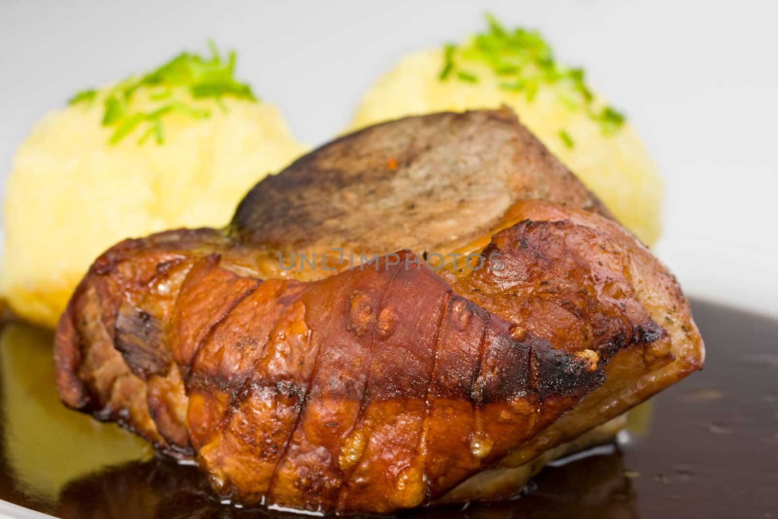 traditional bavarian roast pork with beer sauce and dumplings