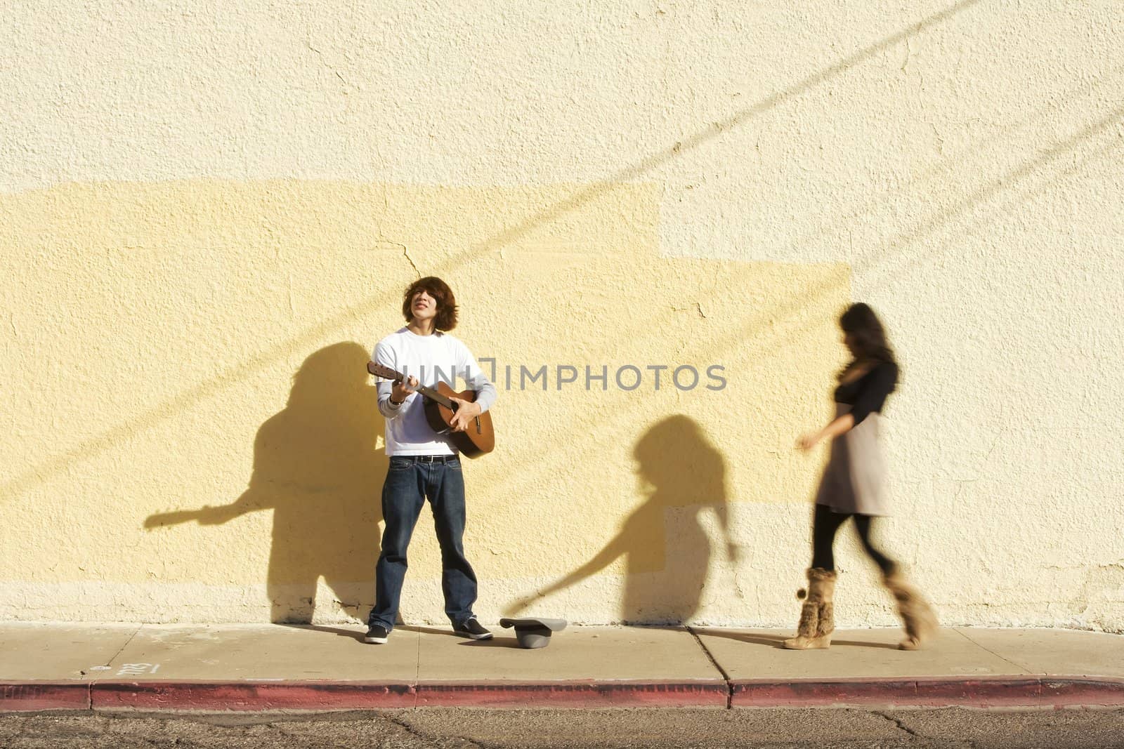 Musician on Sidewalk and Woman Pedestrian Putting Money in Hat