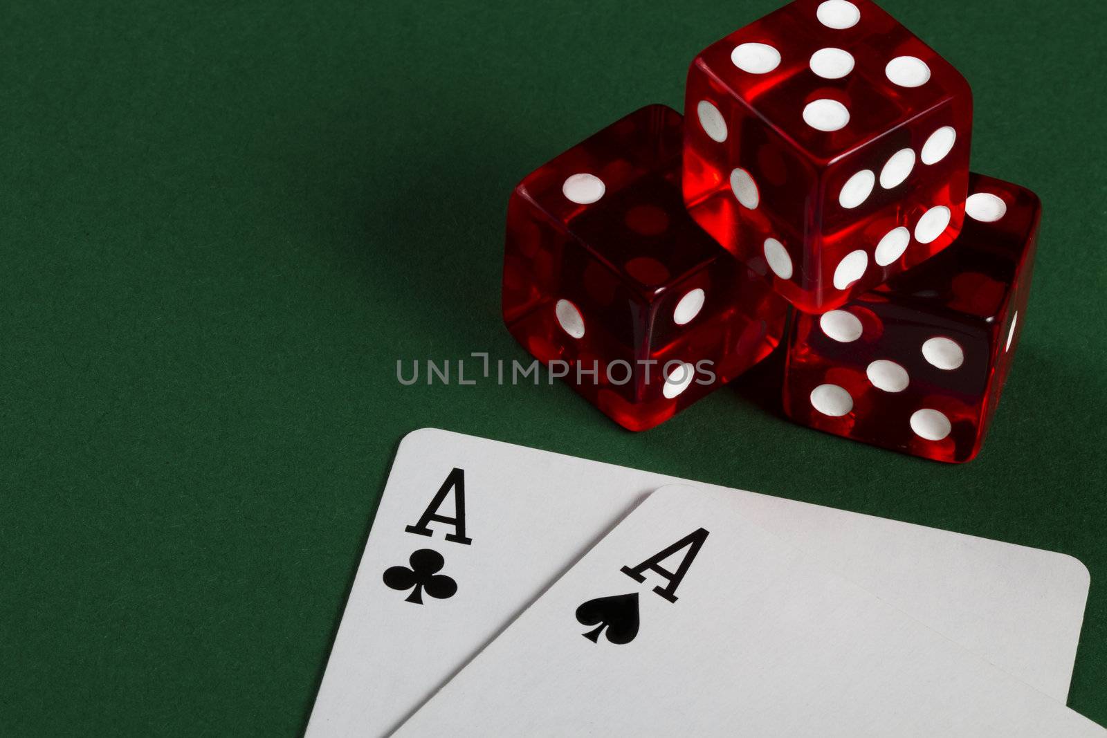 two aces and three dices on green background