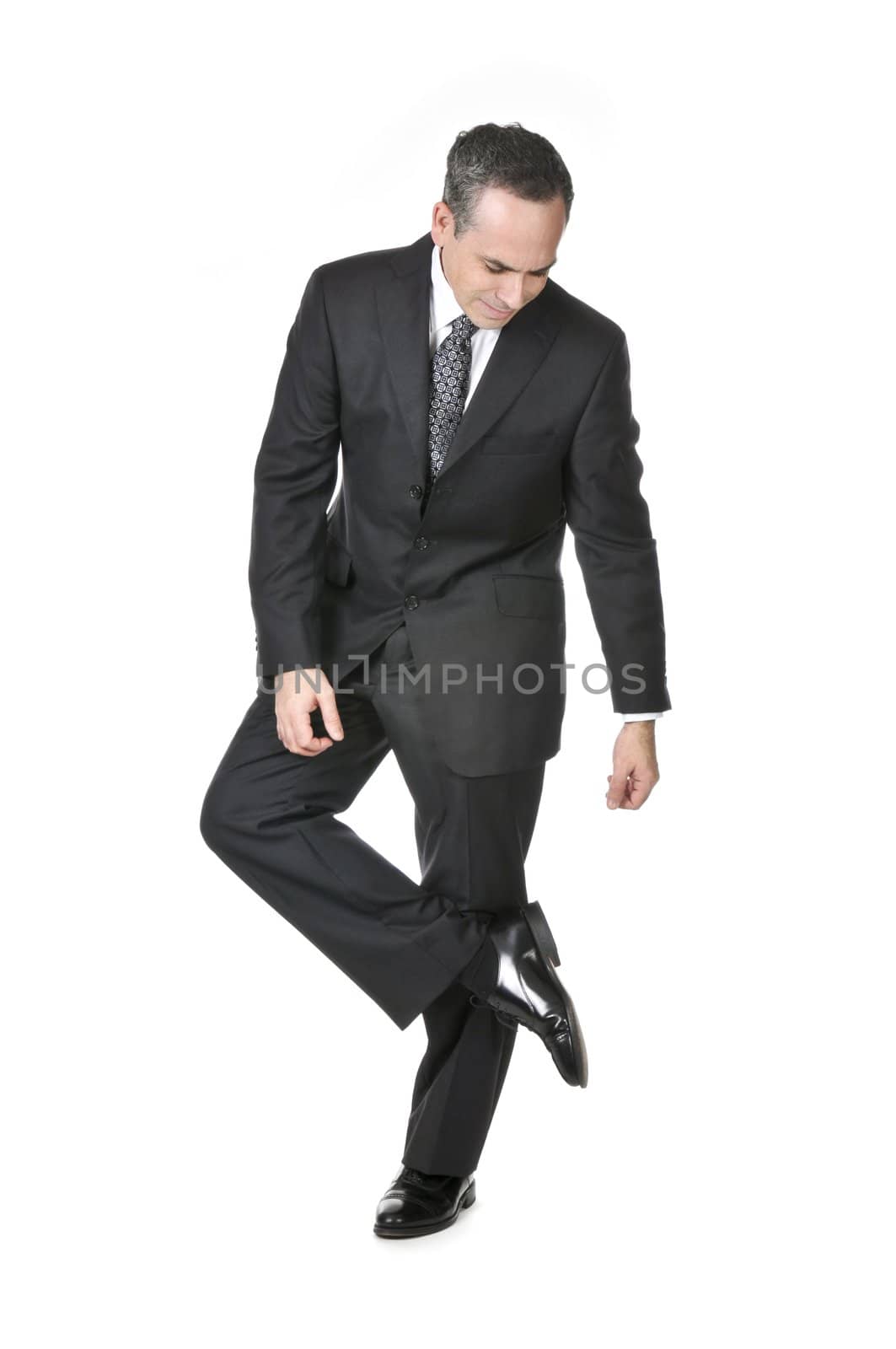 Businessman in a suit looking at his shoe isolated on white background