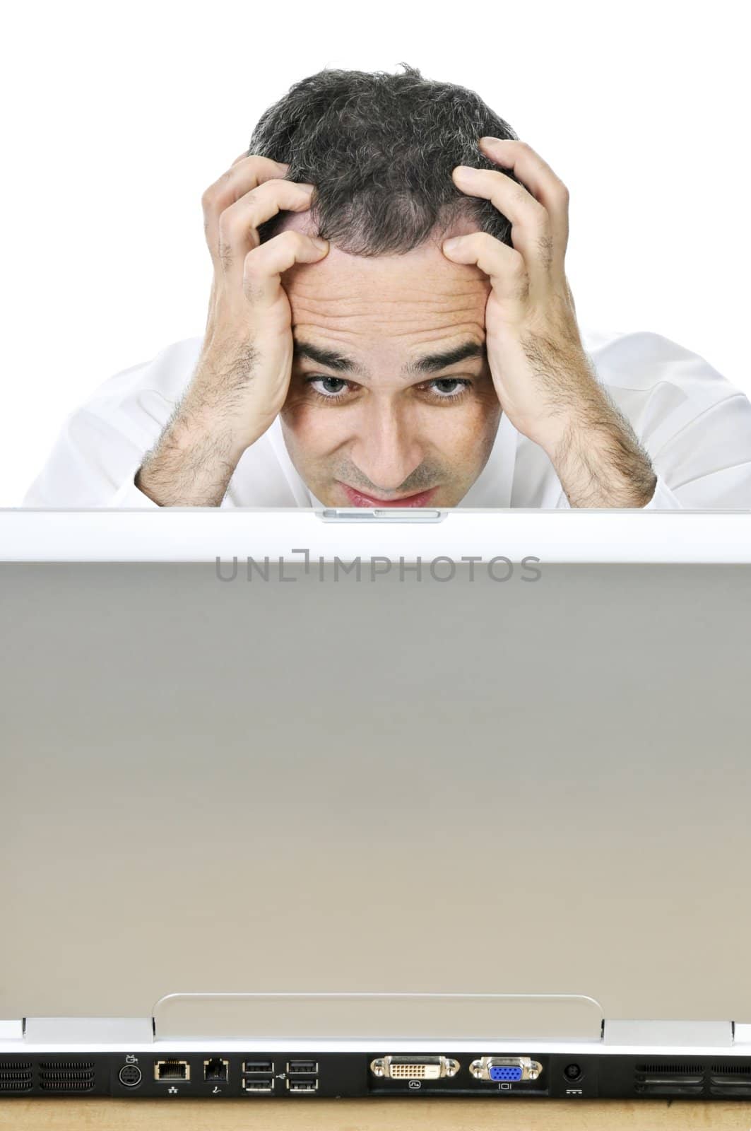 Stressed businessman sitting at his desk isolated on white background