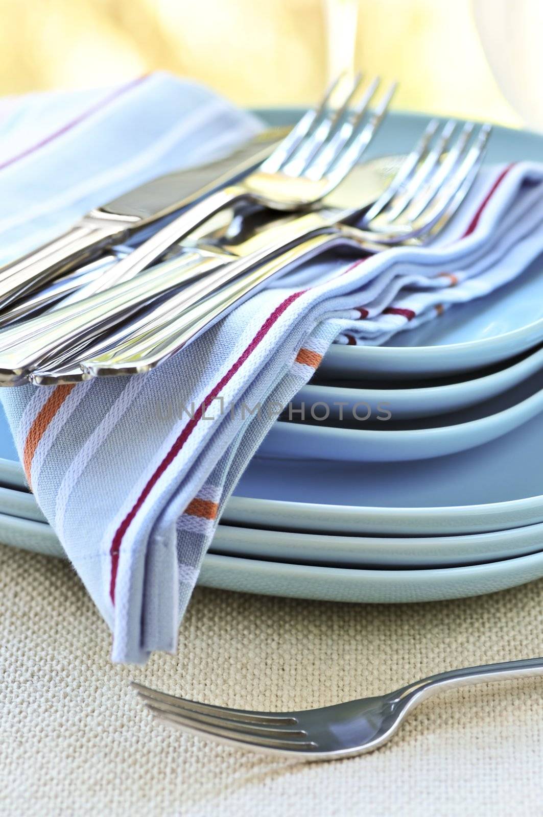 Table setting with stack of plates and cutlery