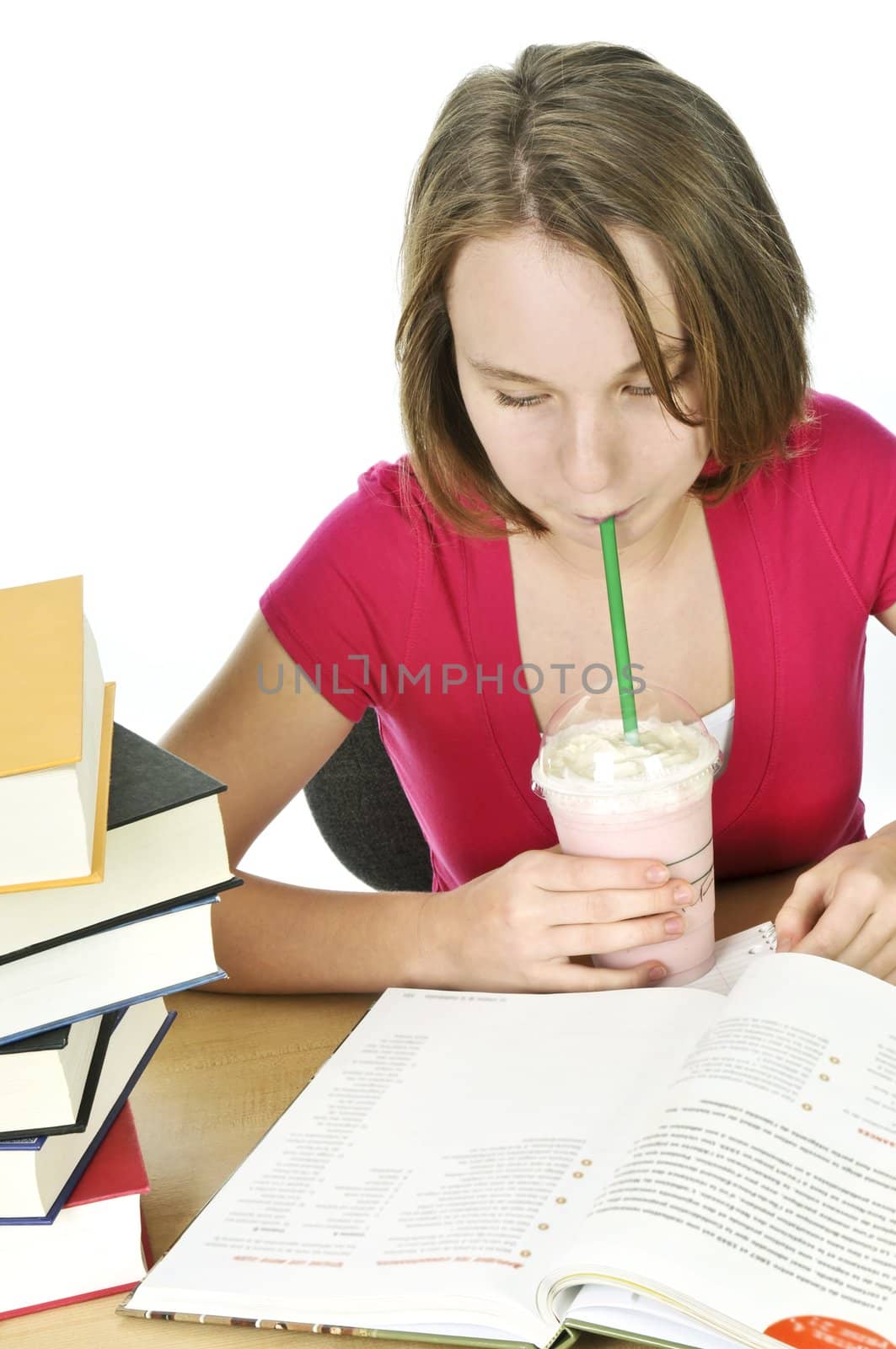 Teenage school girl studying with a milkshake