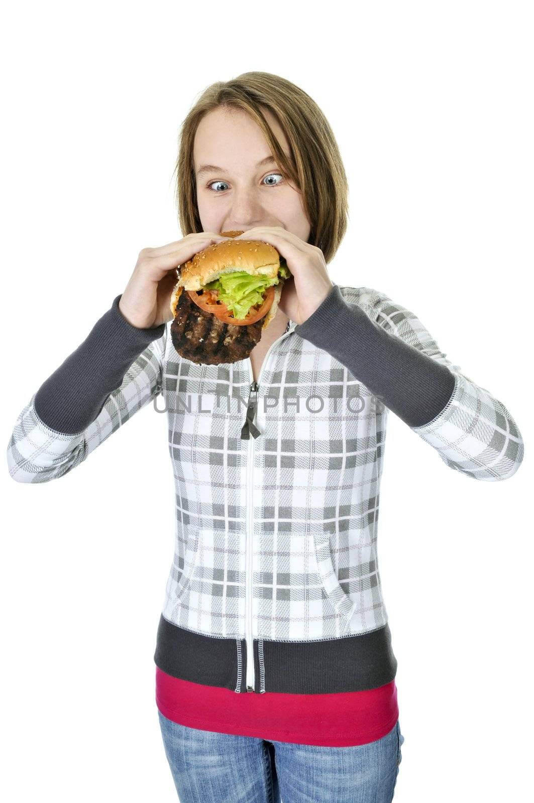 Teenage girl eating a big hamburger isolated on white background