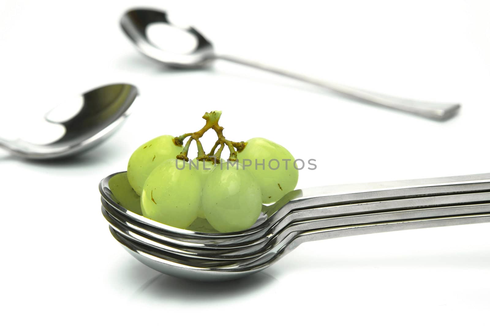 Grapes on a spoon isolated against a white background