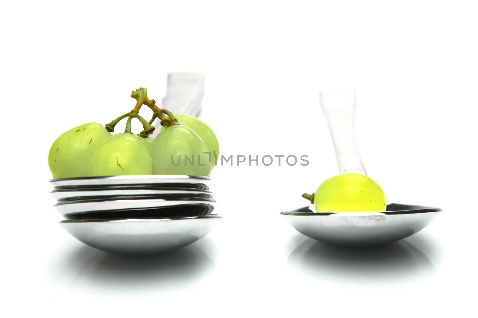 Grapes on a spoon isolated against a white background