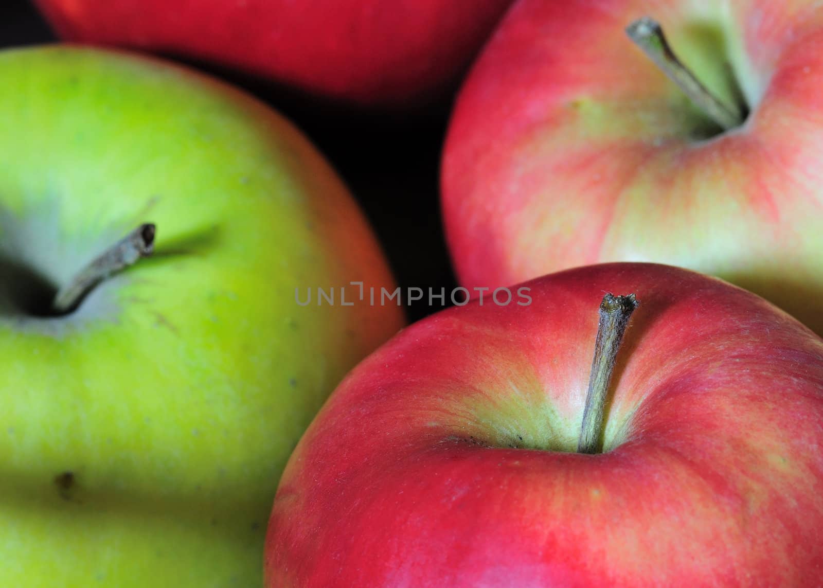 A macro close-up shot of four apples.