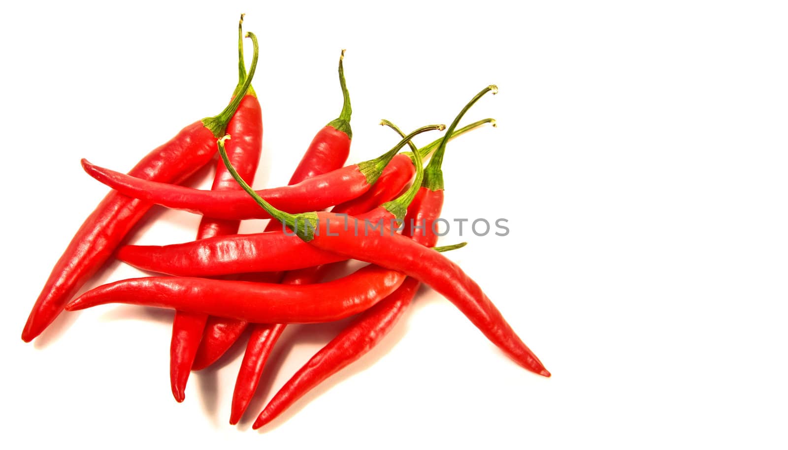 Red peppers laying against a white background