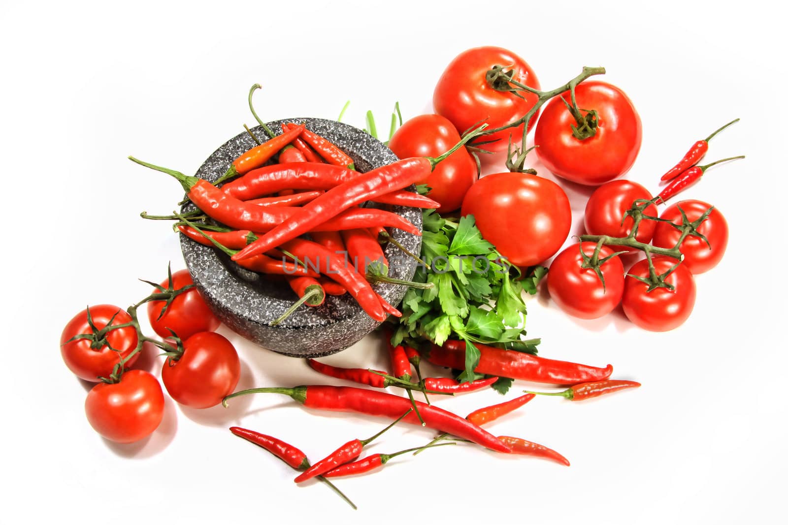 Assortment of red peppers and tomatoes on white background