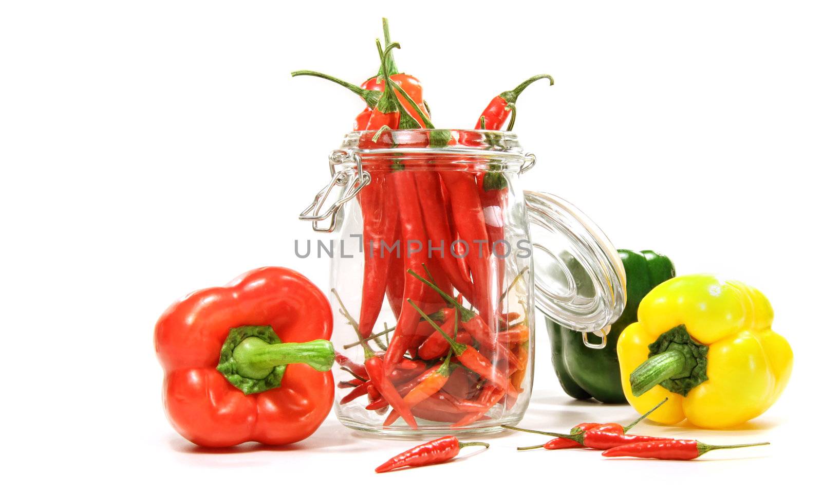 Red peppers in glass jar isolated on white background
