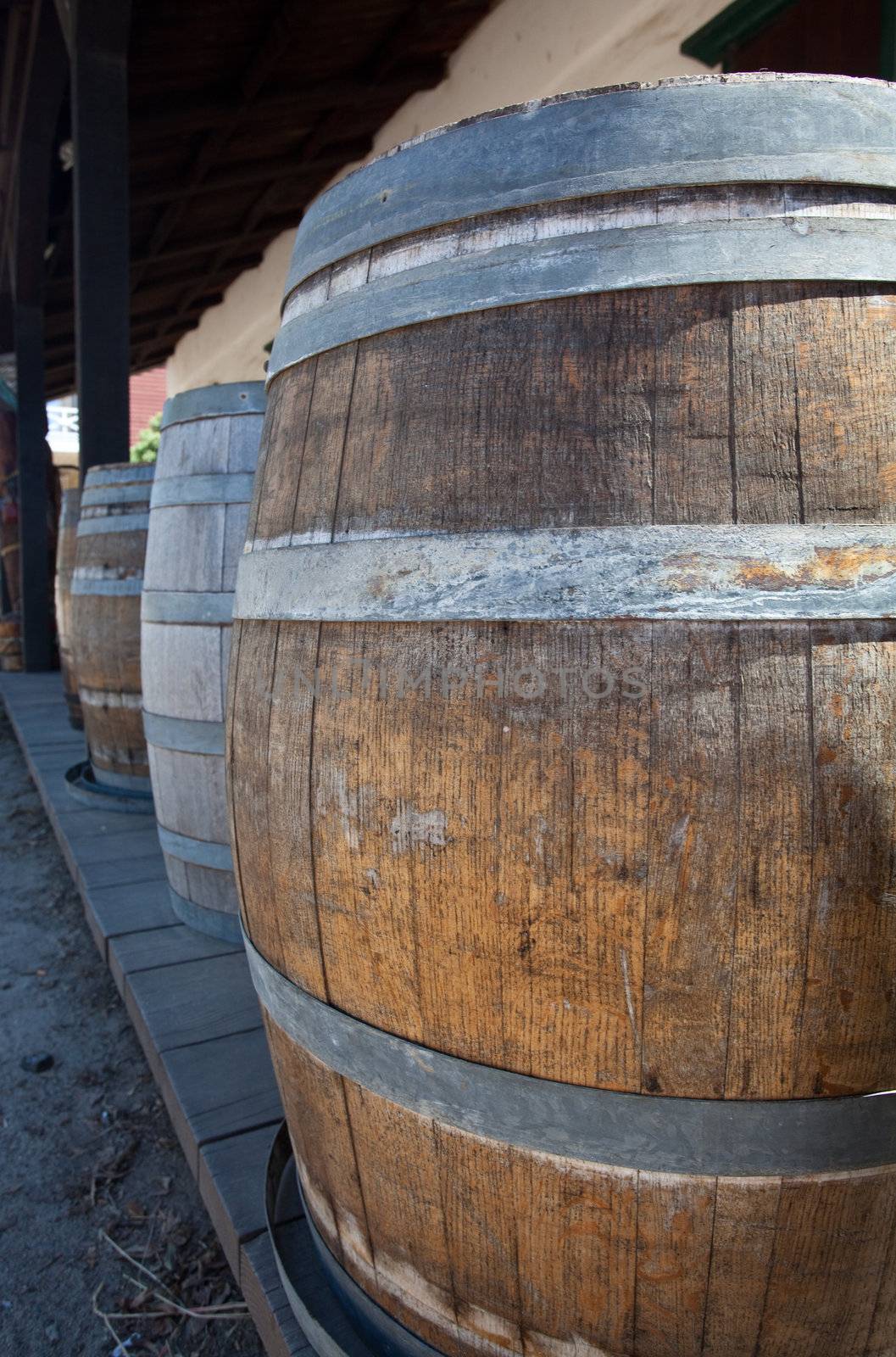 Barrels by old saloon in San Diego by steheap