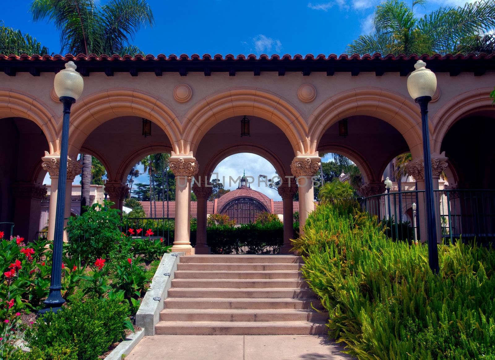 View through the arches of Casa de Balboa building in Balboa Park in San Diego to Botanical Building