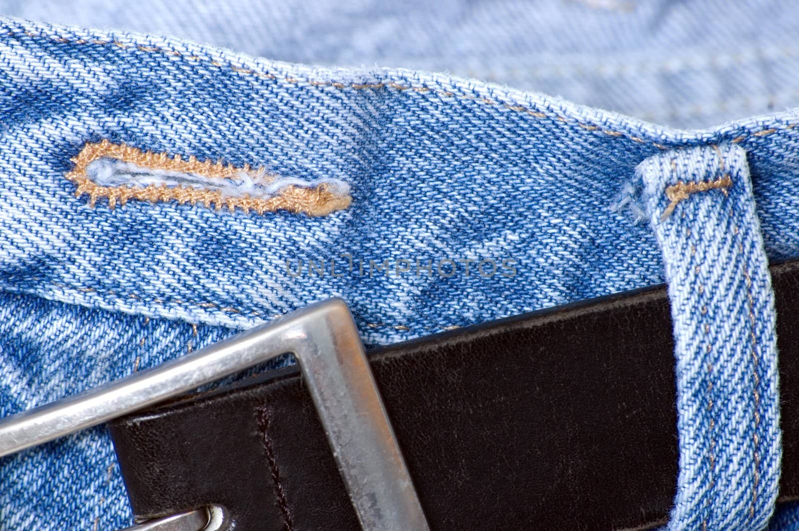 A button hole on a pair of denim jean pants.