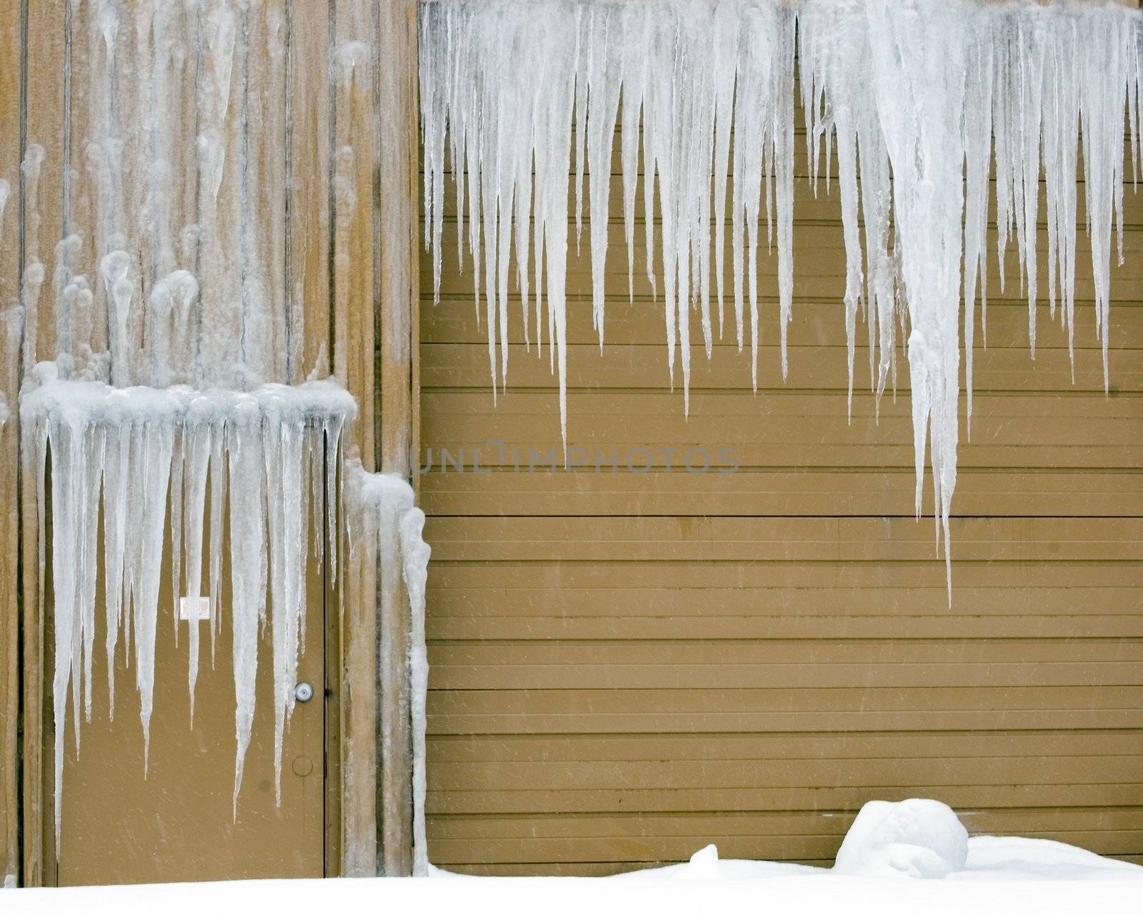 Icicles hanging down on a warehouse door and truck entrance.