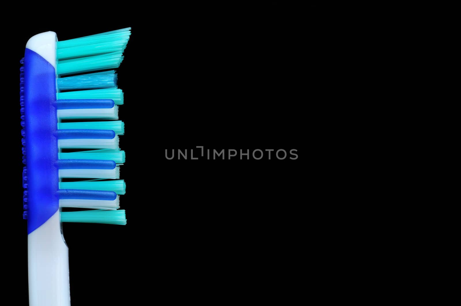 Macro shot of a toothbrush against a black background with copy space.