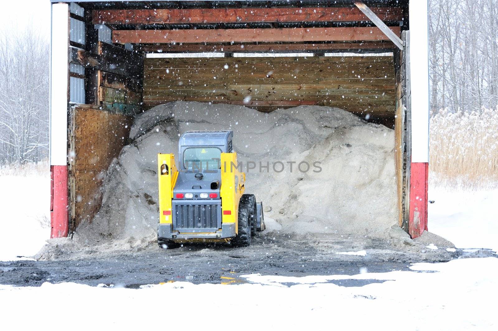 A road salt shelter loaded with salt and a salt loader.