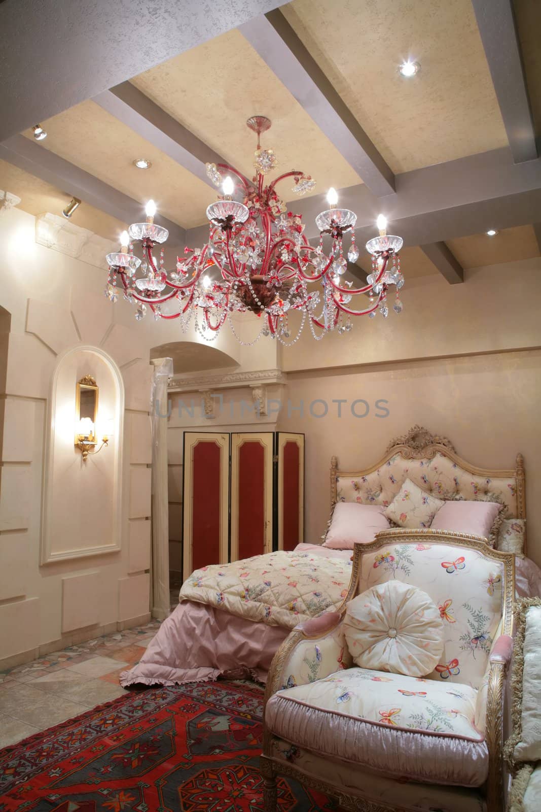 splendid bedroom in classical style with easy chair on luxurious rug under beautiful chandelier