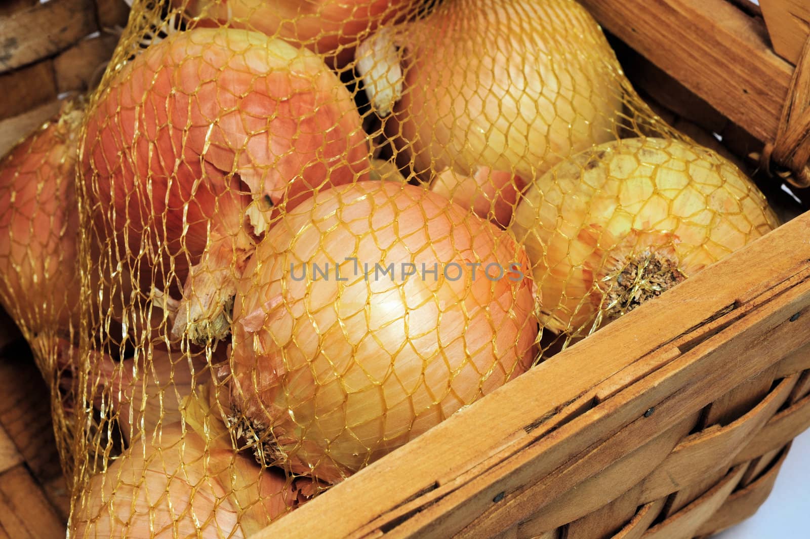 Onions in a mesh bag and wooden basket.