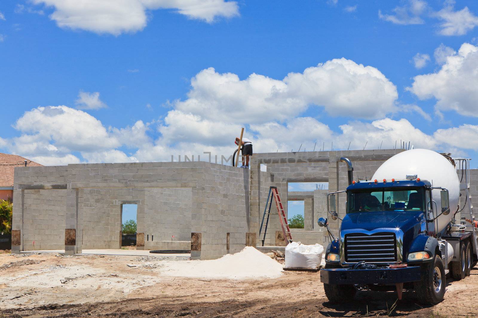 Cement block home with Cement truck, working pouring cement