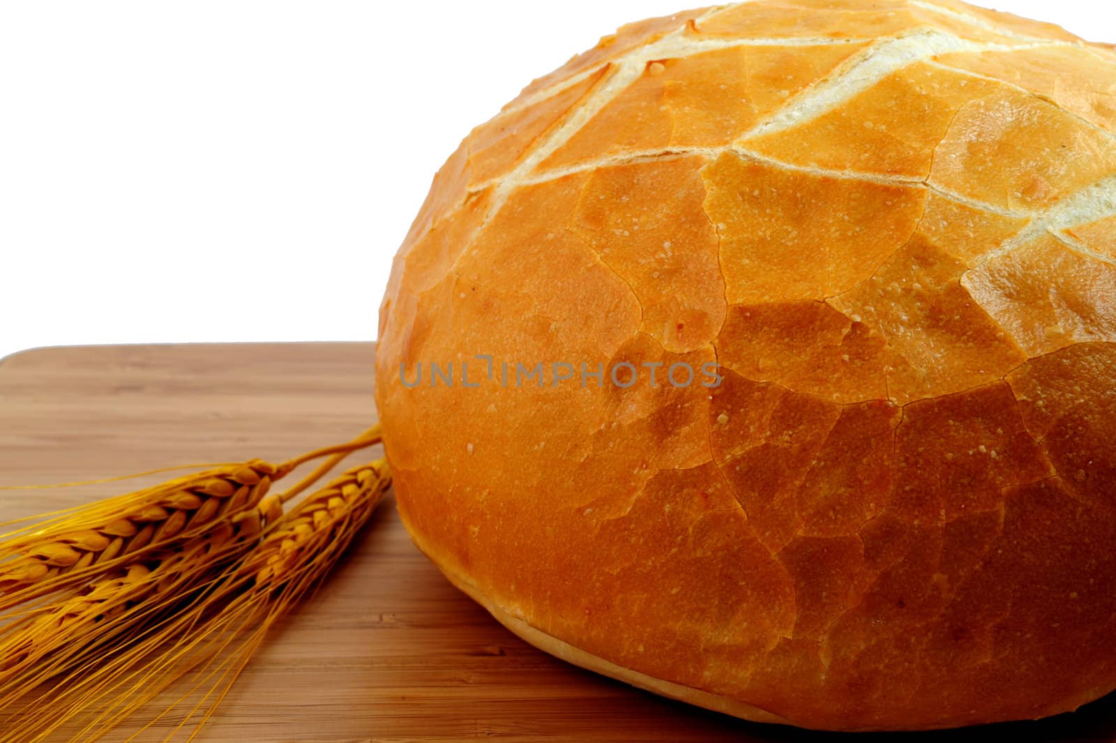 Sourdough bread  and wheat stalks on a cutting board
