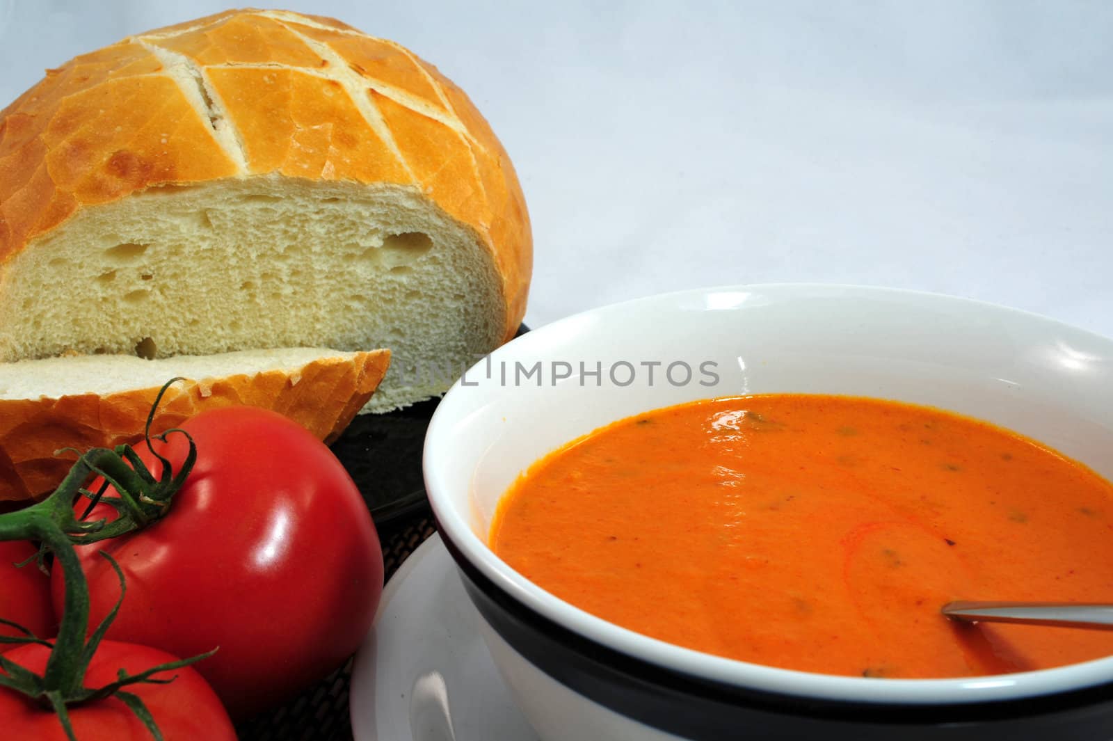 Hot Tomato soup in a bowl with bread on the side